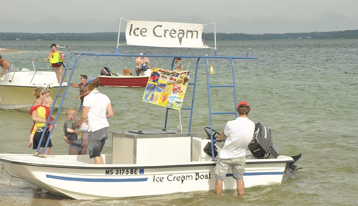 families purchase ice cream from a boat on shore in Cape Cod